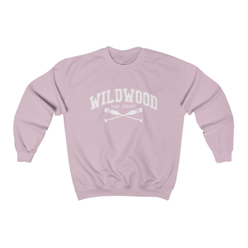 May include: A light pink sweatshirt with the text "WILDWOOD NEW JERSEY" in white with a graphic of two crossed oars.