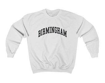 以下が含まれることがあります： 黒い文字で「BIRMINGHAM」とアーチ状のフォントで書かれた白いスウェットシャツです。