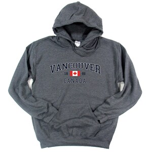 May include: A dark gray hooded sweatshirt with the text "VANCOUVER 18 86 CANADA" and a Canadian flag graphic.