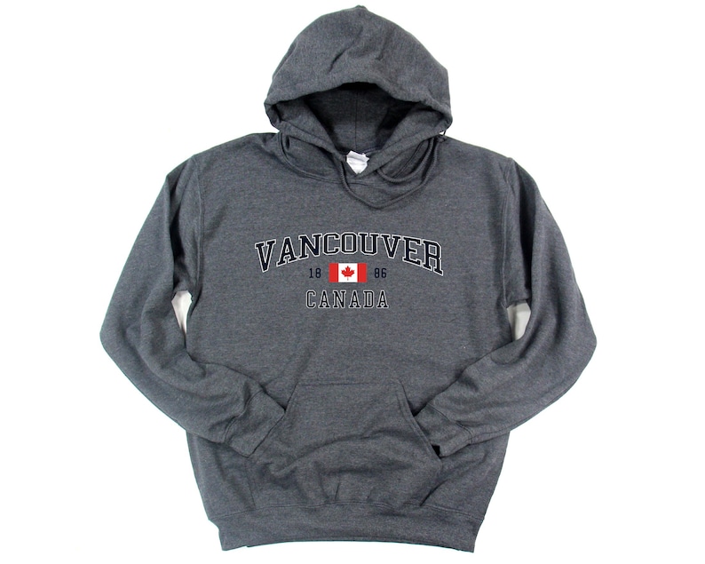 May include: A dark gray hooded sweatshirt with the text "VANCOUVER 18 86 CANADA" and a Canadian flag graphic.