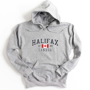 May include: Gray hooded sweatshirt with a navy blue print that says "HALIFAX" with the Canadian flag and "17 49 CANADA" underneath.