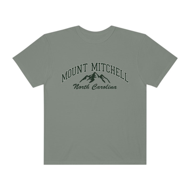 May include: A light gray t-shirt with a green graphic of mountains and the text "MOUNT MITCHELL North Carolina".