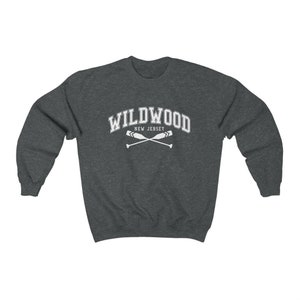 May include: A dark grey sweatshirt with the text "WILDWOOD NEW JERSEY" in white, with a pair of crossed oars underneath.