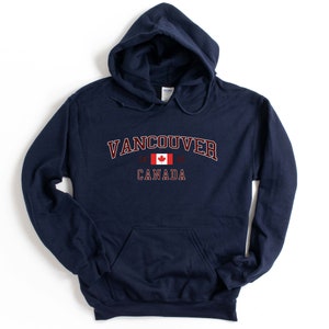 May include: Navy blue hooded sweatshirt with the text "Vancouver, Canada" and a Canadian flag graphic.