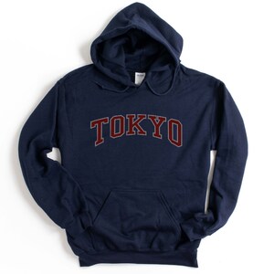 May include: Navy blue hooded sweatshirt with the word "TOKYO" in maroon letters.