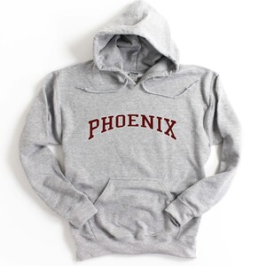 May include: A gray hooded sweatshirt with a maroon "PHOENIX" graphic on the front.