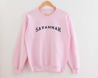 May include: A pink sweatshirt with the word "SAVANNAH" in navy blue lettering.