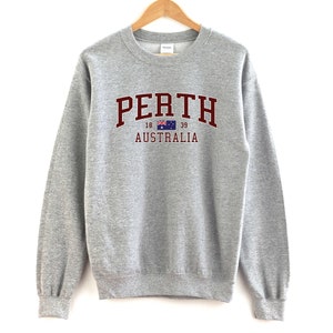 May include: A gray sweatshirt with a maroon print that says "PERTH 18 39 AUSTRALIA" with a small Australian flag.