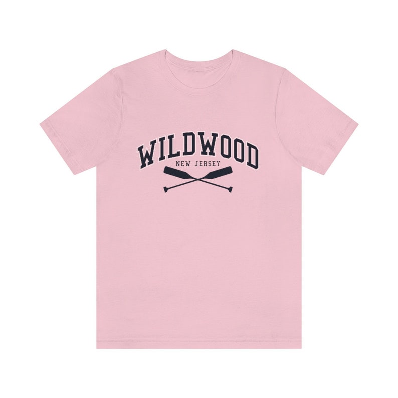 May include: A pink t-shirt with a navy blue graphic of the text "WILDWOOD NEW JERSEY" with two crossed oars.