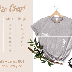 May include: Size chart for a unisex jersey tee shirt, showing measurements in inches for width and length. The chart includes sizes XS to 3XL. The shirt is a light gray color and is hanging on a wooden hanger.