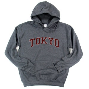 May include: A dark gray hooded sweatshirt with the word "TOKYO" printed in maroon on the front.