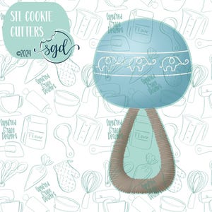 May include: A blue cookie cutter shaped like a rolling pin with a brown handle. The cutter is surrounded by a pattern of kitchen tools and baking supplies, including a whisk, measuring cups, a rolling pin, and a bag of flour. The text "STL COOKIE CUTTERS" and "Sugared Grace Designs" is visible in the image.