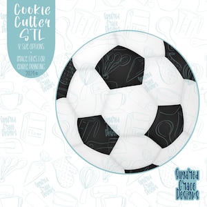 May include: A black and white soccer ball cookie cutter with a blue outline. The background is a white pattern of kitchen tools and the text "Suggared Grace Designs".