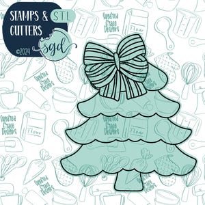 Op de afbeelding: Een turquoise kerstboom met een zwarte omtrek en een grote zwarte strik bovenop. De boom is versierd met een wit achtergrondpatroon van keukengerei en de tekst "Sugared Grace Designs".