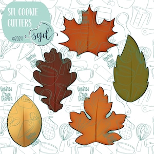May include: Set of four cookie cutters in the shape of autumn leaves. The cutters are made of metal and have a shiny finish. The leaves are in various shades of red, orange, brown, and green.