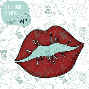 May include: Red cookie cutter in the shape of a pair of lips. The cutter is on a white background with a pattern of kitchen tools and the text "Suggared Grace Designs".