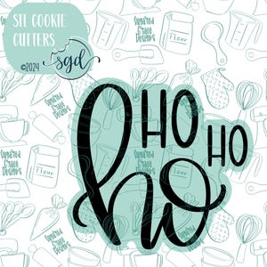 May include: Black and white cookie cutters in the shape of the words "HO HO HO". The cutters are on a white background with a pattern of kitchen tools and the text "Suggared Grace Designs".
