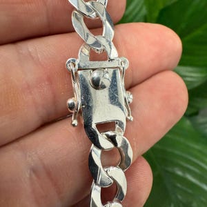 May include: A silver curb chain necklace with a lobster clasp closure.