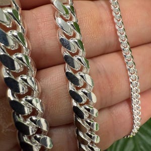 Puede incluir: Tres cadenas de plata de diferentes anchos y longitudes. Las cadenas están hechas de un estilo de eslabón grueso y grueso.