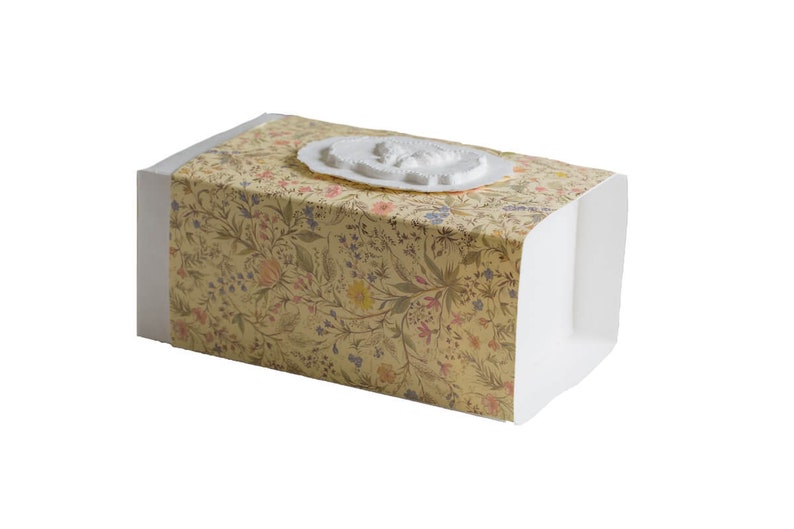Op de afbeelding: Een witte doos met een bloemenpatroon op de bovenkant en zijkanten. De doos heeft een wit reli&euml;fdesign op de bovenkant.