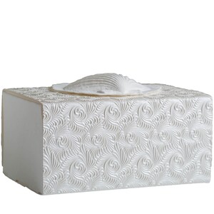 K&ouml;nnte beinhalten: Wei&szlig;e Taschentuchbox mit Muscheldesign. Die Box hat ein strukturiertes, wirbelndes Muster und eine rechteckige Form. Die Muschel ist ebenfalls wei&szlig; und verleiht dem Taschentuchhalter eine dekorative Note.