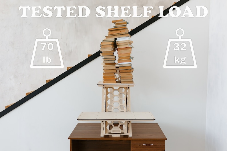 K&ouml;nnte beinhalten: Ein Stehpult aus Holz mit einem Wabenmuster und einem Regal. Das Regal ist mit einem Stapel B&uuml;cher gef&uuml;llt, und das Pult ist mit "TESTED SHELF LOAD" beschriftet und hat eine Gewichtsgrenze von 70 lb oder 32 kg.