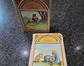 Peut inclure: Deux livres pour enfants vintage de Winnie l'ourson. Le premier livre est vert et intitulé "Pooh et Piglet partent à la chasse et manquent de peu d'attraper un Woozle" par A.A. Milne. Le deuxième livre est rose et intitulé "Eeyore perd sa queue et Pooh en trouve une" par A.A. Milne.