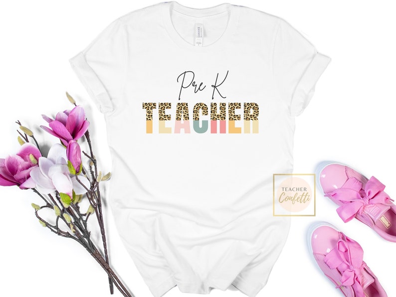Puede incluir: Camiseta blanca con el texto "Pre K TEACHER" en letra negra. La palabra "TEACHER" est&aacute; en estampado de leopardo con un fondo colorido.