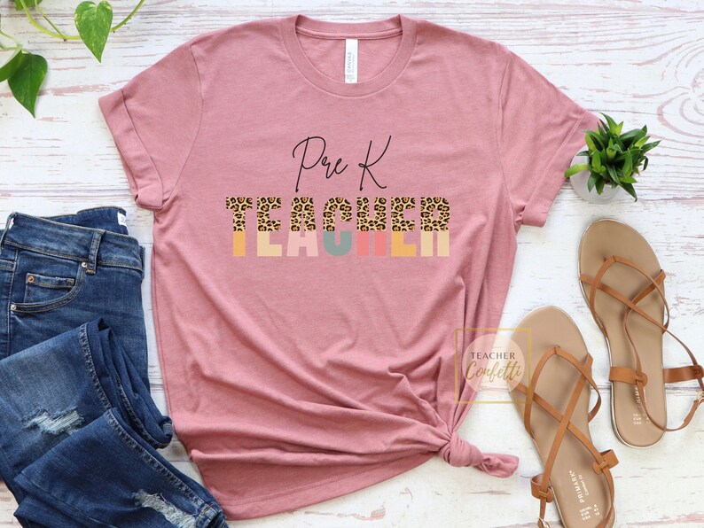 Puede incluir: Una camiseta rosa con el texto "Pre K Teacher" en letra negra. La palabra "Teacher" est&aacute; en letras may&uacute;sculas de colores con un estampado de leopardo.