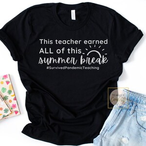 May include: Black t-shirt with white text that reads "This teacher earned ALL of this... summer break #SurvivedPandemicTeaching". The text is stylized with a sun graphic.