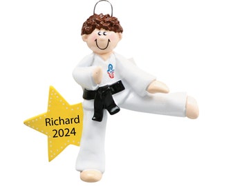 May include: A personalized Christmas ornament featuring a boy in a white karate uniform with a black belt, kicking his leg up. He is smiling and has brown hair. The ornament is decorated with a yellow star with white polka dots and the text "Richard 2024".