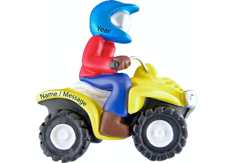 May include: A yellow ATV with a blue helmet wearing rider. The ATV has a white name/message area and the helmet has the word "Year" on it.