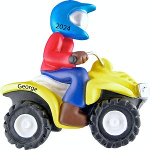 May include: A yellow ATV with a blue helmet and red shirt. The ATV has the name "George" on the side and the number "2024" on the helmet.