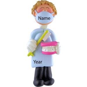 May include: A blue and white personalized ornament of a dentist wearing a face mask and holding a toothbrush and a set of teeth. The ornament has the text "Name" and "Year" on it.