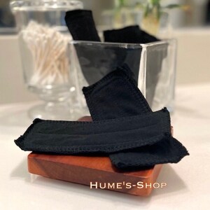 May include: Black reusable makeup remover pads in a glass jar with the text "WINGLESS MINI PAD" and "HUME'S-SHOP" on a wooden surface.