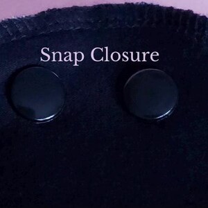 May include: Close-up of a black fabric with two black snap closures. The text "Snap Closure" is above the snaps. The edge of the fabric has a stitched border. The shop name "HUME'S-SHOP" is in the bottom right corner.