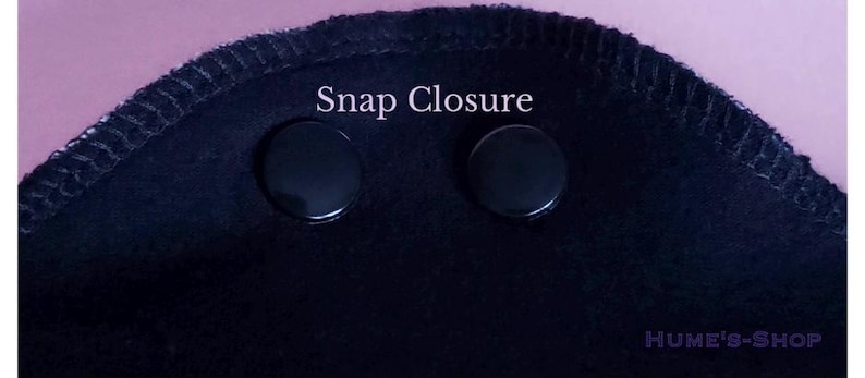 May include: Close-up of a black fabric with two black snap closures. The text "Snap Closure" is above the snaps. The edge of the fabric has a stitched border. The shop name "HUME'S-SHOP" is in the bottom right corner.