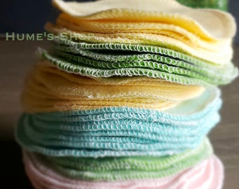 May include: A stack of reusable makeup remover pads in various colors, including yellow, green, blue, and pink. The pads are made of soft, absorbent fabric and are designed to be gentle on the skin.