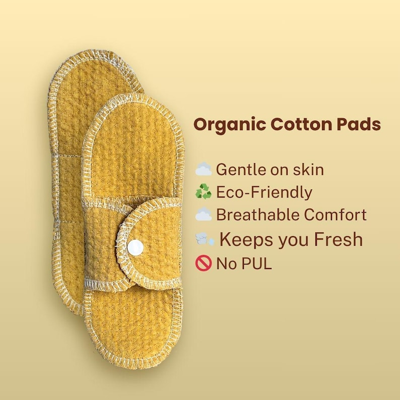 Two Golden Sand organic cotton cloth pads beside text listing breathable comfort, gentle fabric, reusable construction, and no PUL waterproof layer.menstrual products.