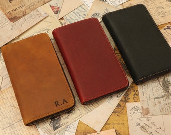 May include: Three leather zippered wallets in brown, red, and black. The brown wallet has the initials "R.A." embossed on the front.