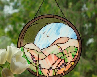 Handgemachter Suncatcher aus der Glasmalerei mit Blick auf die Berge