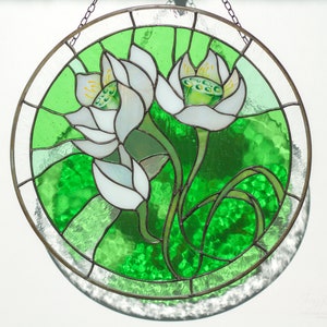 Detailed close-up of the stained glass panel with white lilies, showing the texture of the bright green art glass and the soldered seams; a thoughtful Mothers day gift or grandma gift.