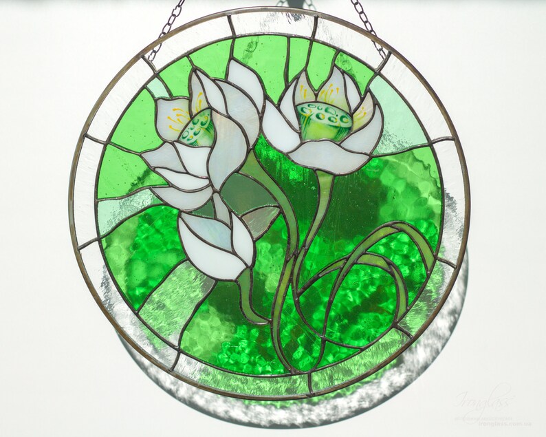 Detailed close-up of the stained glass panel with white lilies, showing the texture of the bright green art glass and the soldered seams; a thoughtful Mothers day gift or grandma gift.
