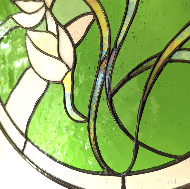 Highly detailed macro shot of the stained glass panel, focusing on the shimmering Tiffany glass art stems with blue and yellow iridescent glass, showcasing the unique quality of the garden flower decor artwork.