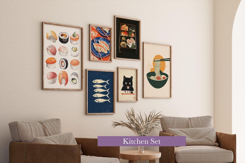May include: A collection of framed art prints featuring sushi, fish, and ramen illustrations. The prints are in wooden frames and are displayed on a white wall above a brown sofa and chair. The text "Kitchen Set" is displayed on a purple banner.