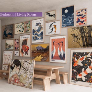 May include: A collection of framed art prints with Japanese-inspired designs, including landscapes, koi fish, and cranes. The prints are displayed on a wall above a wooden table and bench, creating a gallery wall aesthetic.