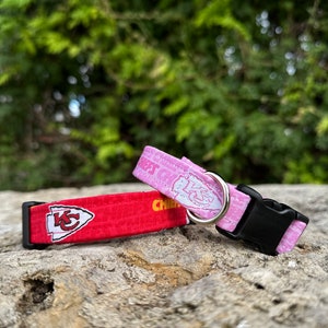 Puede incluir: Dos collares para perros, uno rojo con el logotipo de los Kansas City Chiefs y el otro rosa con un dise&ntilde;o blanco. Ambos collares tienen hebillas negras.