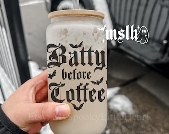May include: A clear glass tumbler with a bamboo lid and a black straw. The tumbler has a black graphic that says "Batty before Coffee" with bats around the text.