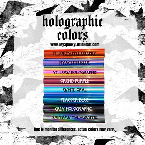 May include: A collection of holographic vinyl sheets in various colors, including fluorescent orange, hyacinth blue, yellow holographic, orchid purple, white opal, peacock blue, grey holographic, and rainbow holographic. The text "holographic colors" and "www.MySpookyLittleHeart.com" is displayed above the sheets. The text "Due to monitor differences, actual colors may vary." is displayed below the sheets.
