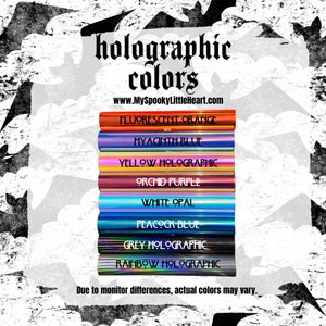 May include: A collection of holographic vinyl sheets in various colors, including fluorescent orange, hyacinth blue, yellow holographic, orchid purple, white opal, peacock blue, grey holographic, and rainbow holographic. The text "holographic colors" and "www.MySpookyLittleHeart.com" is displayed above the sheets. The text "Due to monitor differences, actual colors may vary." is displayed below the sheets.